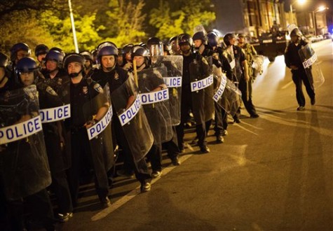 Police in riot gear line up near the scene of Monday's riots ahead of a 10 p.m. curfew Wednesday, April 29, 2015, in Baltimore. The curfew was imposed after unrest in Baltimore over the death of Freddie Gray while in police custody. (AP Photo/David Goldman)