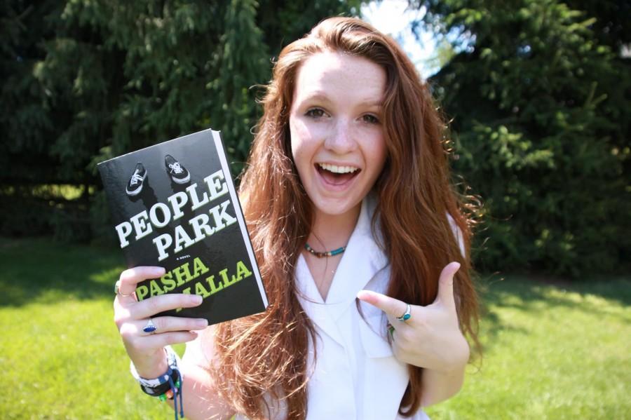 Jess poses with the book People Park that features her photography on the cover.