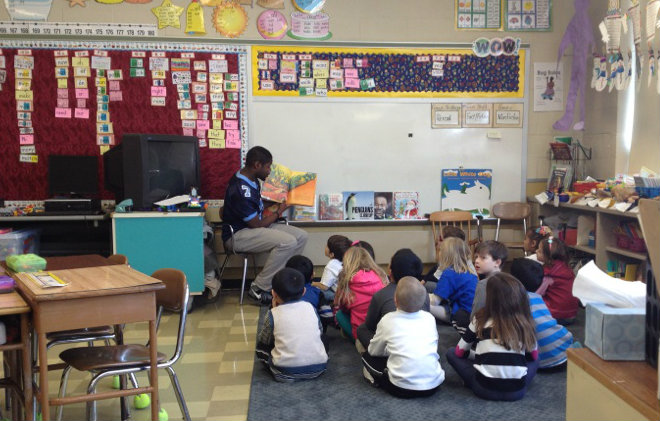 Players exchange their footballs for books at the Reading Super Bowl