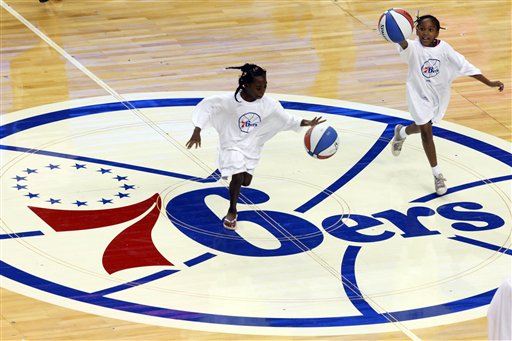 Children practice on the newly designed Philadelphia 76ers basketball court for the upcoming 2009-10 season, during the Summer Hoops Tour basketball clinic, in Philadelphia, Monday, Aug. 10, 2009.  The logo was last used in the 1996-97 season. (AP Photo/Matt Rourke)