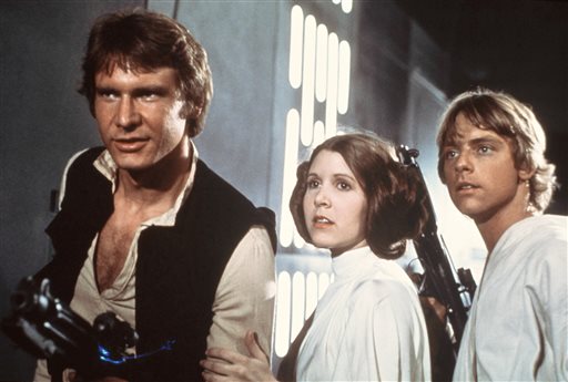 In this 1977 image provided by 20th Century-Fox Film Corporation, from left,  Harrison Ford, Carrie Fisher, and Mark Hamill are shown in a scene from Star Wars movie released by 20th Century-Fox. Disney is previewing several of the studios upcoming live-action films for fans at the D23 Expo, Aug. 9-11, 2013, a three-day Disney extravaganza at the Anaheim Convention Center. Disney bought George Lucas Lucasfilm empire last year for $4.06 billion and plans to unleash a new Star Wars trilogy and two spin-off films beginning in 2015 with Star Wars: Episode VII, which is being directed by J.J. Abrams and written by Michael Arndt. (AP Photo/20th Century-Fox Film Corporation)