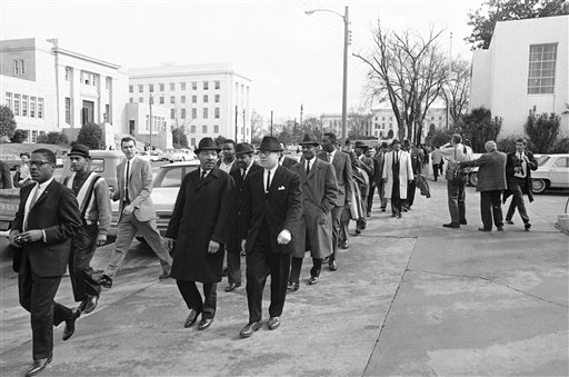 Dr. Martin Luther King, left, heads a column of about 200 African Americans in a four-block march to the courthouse spearheading a voter registration drive in Montgomery, Alabama on Feb. 9, 1965. State capitol building in right background. (AP Photo/Horace Cort)