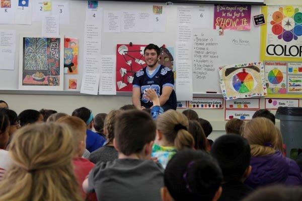 Senior football player Corey Colby answers questions from North Wales Elementary Schools fourth grade class.