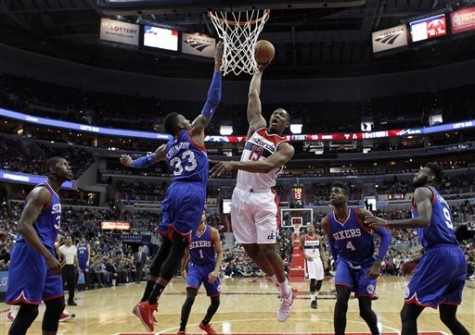 Washington Wizards center Kevin Seraphin (13), from France, dunks in front of Philadelphia 76ers forward Robert Covington (33) in the first half of an NBA basketball game, Monday, Jan. 19, 2015, in Washington. The Wizards won 111-76. (AP Photo/Alex Brandon)