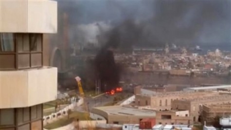 In this image made from video posted by a Libyan blogger, the Cortinthia Hotel is seen under attack in Tripoli, Libya,  Tuesday, Jan. 27, 2015. Gunmen stormed the luxury hotel in the Libyan capital of Tripoli on Tuesday, killing several foreigners and guards, officials said. The attack, which included a car bombing, struck the hotel, which sits along the Mediterranean Sea. The blogger, @AliTweel, captured the moments shortly after the blast, when flames rose up from outside the hotel, appearing to be from the aftermath of the car bomb. (AP Photo/ @AliTweel via AP video)
