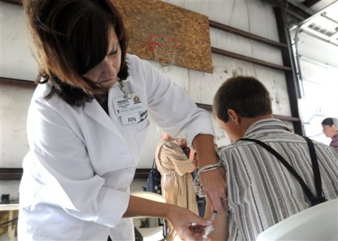 In this June 25, 2014 photo, Richland Public Health nurse Renee Blankenship, left, gives Marcus Burkholder a Measles, Mumps, & Rubella (MMR) vaccination at a clinic for the Mennonite community in Richland County in Shiloh, Ohio. Health officials said Ohios current outbreak of measles consists of more than 360 cases and is the biggest in the U.S. since 1994. (AP Photo/Tom E. Puskar)