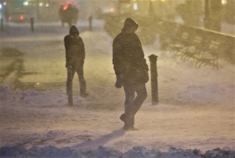 Pedestrians walk through wind-swept snow in downtown Brooklyn, Monday, Jan. 26, 2015, in New York. More than 35 million people along the northeast corridor rushed to get home and settle in Monday as a fearsome storm swirled in with the potential for hurricane-force winds and 1 to 3 feet of snow that could paralyze the Northeast for days. (AP Photo/Bebeto Matthews)