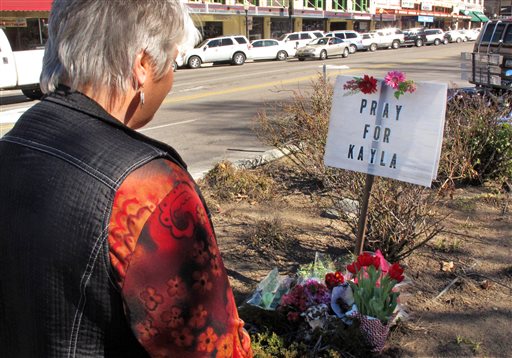 Laura Spaeth looks at a memorial honoring American hostage Kayla Mueller on the corner of courthouse plaza in Prescott, Ariz.,  Tuesday, Feb. 10, 2015.  Islamic State group reported Friday that Muller, whose 18-month captivity had largely been kept secret in an effort to save her, had died in a recent Jordanian airstrike targeting the militants. On Tuesday her parents and U.S. officials confirmed she was dead, although officials said they could not confirm how she died.  (AP Photo/Felicia Fonseca)