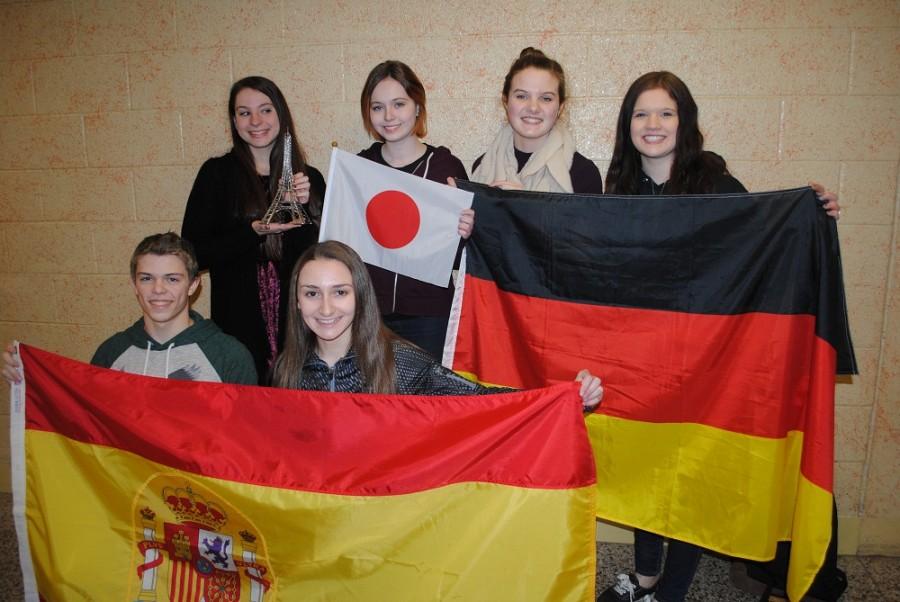The recently chosen exchange students pose for a picture with the flags of their individual countries - (top left to right) Brittany Van Strein, Jackie Bumgarner, Sydney Juska, and Leanne Spiegle, (bottom left to right) Nolan Marett, and Taylor Young. 