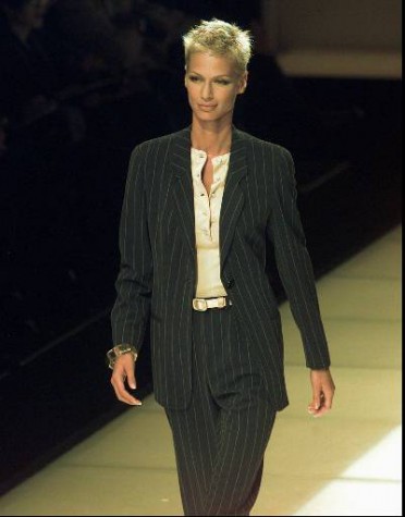 This tailored pin-striped pantsuit worn with a collarless white silk blouse and matching white belt was part of Giorgio Armanis Spring-Summer fashion collection in Milan Sunday, October 6 1996. (AP Photo/Luca Bruno)