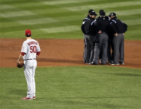 FILE - In this Oct. 23, 2013, file photo, St. Louis Cardinals starting pitcher Adam Wainwright watches as umpires discuss a ruling during the first inning of Game 1 of baseball's World Series against the Boston Red Sox in Boston. Major League Baseball announced Thursday, Jan. 16, 2014, that it will greatly expand instant replay to review close calls starting this season. Each manager will be allowed to challenge at least one call per game. If he's right, he gets another challenge.  After the seventh inning, a crew chief can request a review on his own. (AP Photo/Charles Krupa, File)