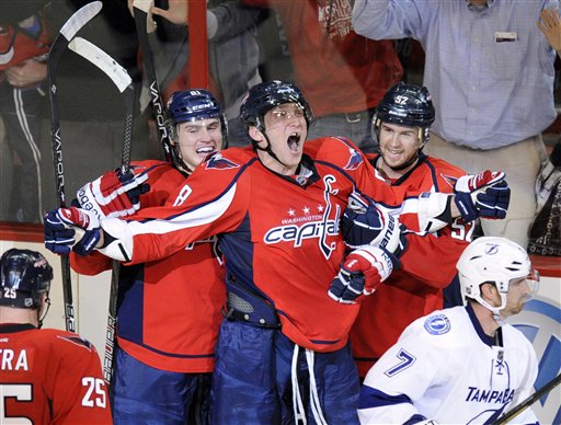 FILE - In this March 8, 2012 file photo, Washington Capitals left wing Alex Ovechkin, center, of Russia, screams and celebrates his game-winning goal with teammates Mike Green, right, Dmitry Orlov, of Russia, second from left, and Jason Chimera (25) as Tampa Bay Lightning defenseman Brett Clark (7) skates away during the overtime period of an NHL hockey game in Washington. Ovechkin is returning to his former Russian team Dynamo Moscow during the NHL lockout. The KHL team said in a statement Wednesday, Sept. 19, 2012, that it has signed the Capitals star to a contract that lasts until the lockout ends.  (AP Photo/Nick Wass, File)