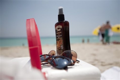 This Wednesday, May 9, 2012 file photo shows a bottle of sun tan lotion and sunglasses on top of a cooler carried onto Miami Beach, Fla. by tourists. Sunscreen confusion wont be over before summer after all. The government is bowing to industry requests for more time to make clear how much protection their lotions really offer.  (AP Photo/J Pat Carter, File)