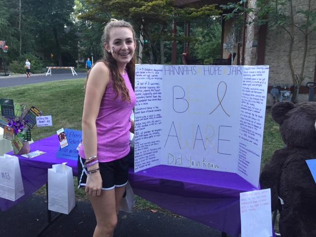 Hannah Gardner, junior at NPHS and founder of Hannah’s Hope Jar, pictured with a poster that states facts regarding childhood cancer.
