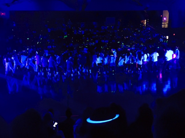 The 2016 class cabinet, Homecoming Court, cheerleaders and dance team dance together to finish off the very first black light pep rally.