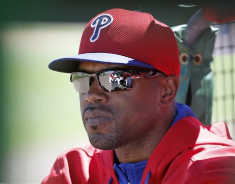 Philadelphia Phillies Jimmy Rollins sits in the dugout after not playing for the third consecutive game during a spring exhibition baseball game against the New York Yankees in Clearwater, Fla., Thursday, March 13, 2014.  Rollins said the situation was unusual, and that he is healthy, therefore he is not sure why Phillies manager Ryne Sandberg is not playing him. (AP Photo/Kathy Willens)
