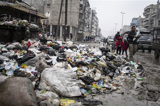 A family crosses a street piled with rubbish in Aleppo, Syria, Saturday, Jan. 5, 2013. The revolt against President Bashar Assad started in March 2011 began with peaceful protests but morphed into a civil war that has killed more than 60,000 people, according to a recent United Nations recent estimate. (AP Photo/Andoni Lubaki)