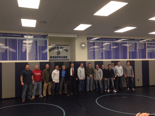 Wall of Honor: Alumni members of the NPHS wrestling team, along with current coach Robert Shettsline pose in front of the new records boards located in the NPHS Wrestling room. The wall of fame was unveiled during a ceremony at NPHS on Nov. 7th. 