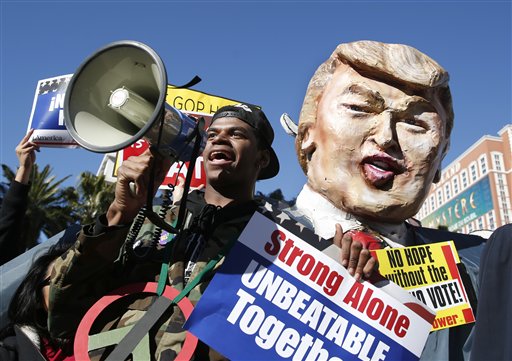 Protestors carrying a likeness of Republican presidential candidate Donald Trump gather outside the Venetian Hotel & Casino before the CNN Republican presidential debate on Tuesday, Dec. 15, 2015, in Las Vegas. (AP Photo/John Locher)