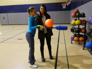 North Penn's Katie Shunk (left) tests out Owens' hand grips with assistance from senior career study student Emily Suzuki (right).