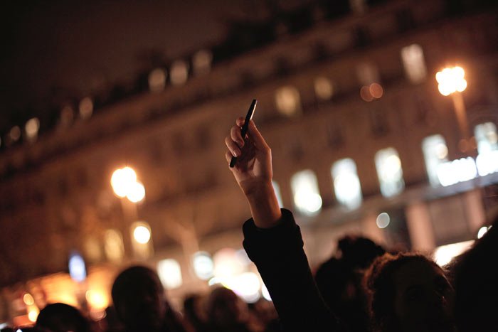 A woman holds up a pen during a gathering in solidarity of the victims of a terror attack against French satirical newspaper Charlie Hebdo in Paris. (Source: AP Photo)