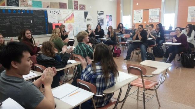 Creative Writing 2 students clap after hearing a classmates free write.