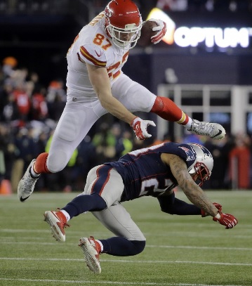 Kansas City Chiefs tight end Travis Kelce (87) leaps over New England Patriots safety Patrick Chung (23) after catching a pass in the first half of an NFL divisional playoff football game, Saturday, Jan. 16, 2016, in Foxborough, Mass. (AP Photo/Steven Senne)