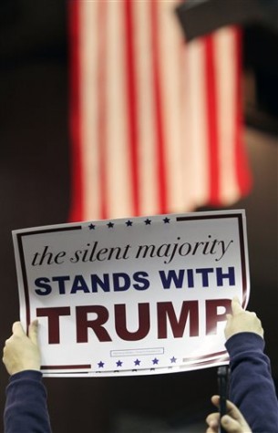A Trump supporter holds a campaign sign as Republican presidential candidate Donald Trump speaks during a campaign rally at the Pensacola Bay Center in Pensacola, Fla., Wednesday, Jan. 13, 2016. (AP Photo/Michael Snyder)