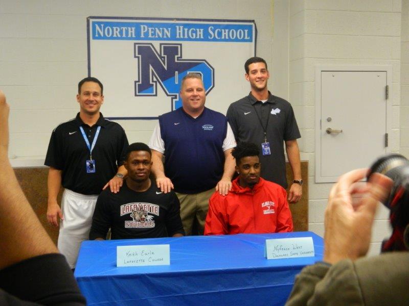 Keith Earle and Nyfease West sign letters of intent on National Signing Day. They are shown with football coaches Dave Franek, Dick Beck, and Kyle Feiser.