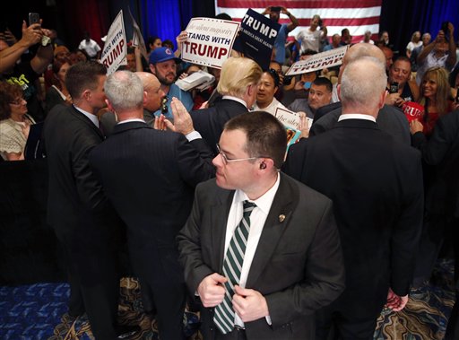 In this March 14, 2016, photo, Secret Service agents surround Republican presidential candidate Donald Trump as he greets supporters after speaking at a campaign event in Tampa, Fla. The security ring protecting Trump includes Secret Service agents, his own private bodyguards, local police, sometimes even the Transportation Security Administration. But even that show of force has not halted disturbing episodes of violence. The only person who can stop Trump from egging on the brawling crowds is Trump himself. 