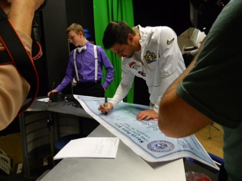 Brandon McManus autographs the check presented to him on behalf of the Anti-Bully Squad.