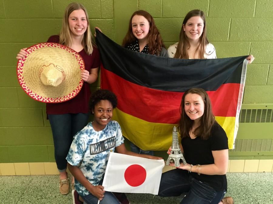 The recently selected 2016-2017 exchange students pose for a picture with flags and symbols of their host countries - Bottom (left to right) Mytia McAlary, Morgan Nadeau. Top (left to right) Kaitlyn Van Dame, Grace Lewis, Mary Beth Nieman