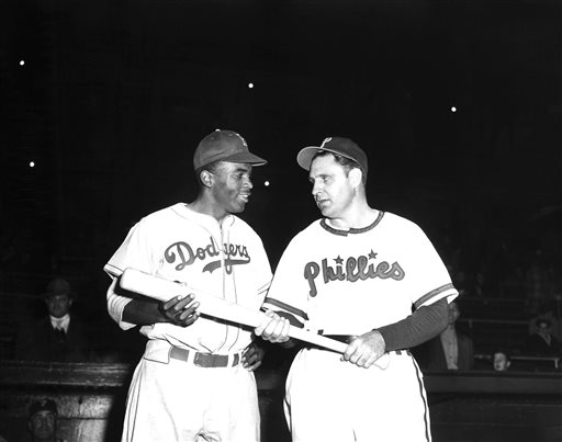 FILE - In a May 9, 1947 file photo, Jackie Robinson, left, Brooklyn Dodgers first baseman, looks over the bat Philadelphia Phillies manager Ben Chapman uses during practice, as he prepared to play his first Philadelphia game for the Dodgers. The Philadelphia City Council unanimously passed a resolution Thursday, March 31, 2016, naming April 15, 2016 as a day to honor Robinsons achievements and to apologize for the racism he faced while visiting Philadelphia in 1947. Robinson was refused service by a local hotel and then taunted by Philadelphia Phillies manager Ben Chapman, who, along with players, mercilessly hurled racial slurs at Robinson each time he came to bat. (AP Photo, File)