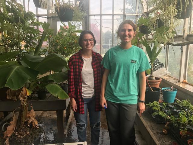 Andrea Canavan, left, and Mikala Camburn, right, posed for a photo in NPHSs greenhouse during 9th period, as they worked on their projects and prepared for the programs club meeting. (Not pictured: Sean Rice, work study student)
