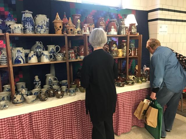 Two customers browse through the pottery being sold by Dan Watt, an employee of Eldreth Pottery. Watt has attended the craft show since 1986 or for 60 shows.