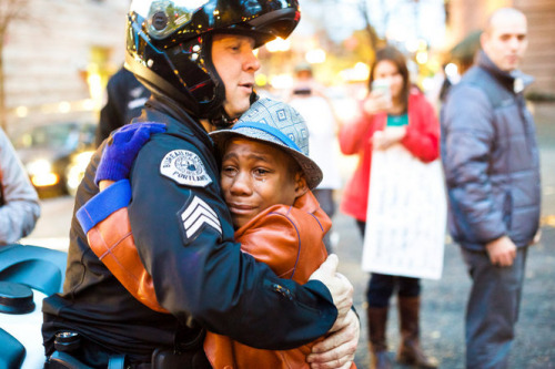 A Police Officer and a Black Lives Matter supporter embrace during a protest in Portland, Oregon on November 25 , 2014.