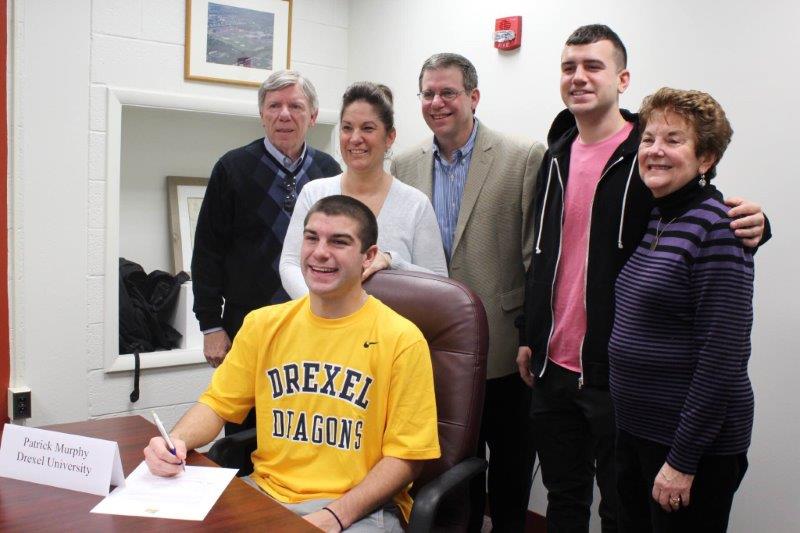 Patrick Murphy, North Penn senior, signs his letter of intent surround by his family: grandfather Ray, mother, Karin, father, Terry, brother Sean, and grandmother, Nancy