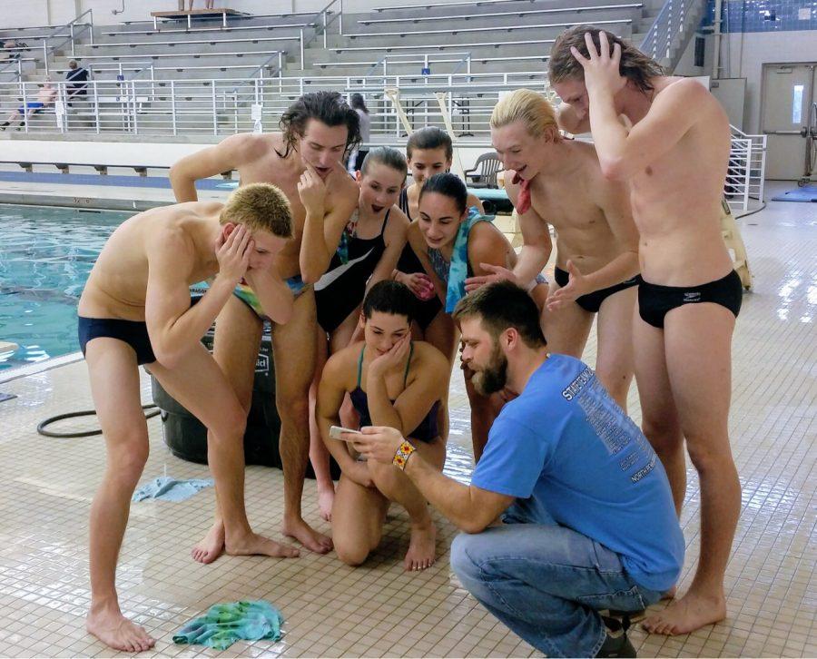 NP divers are with assistant coach Kyle Kushner watching a live stream of Marie Yacopino, a former NP diver, competing in her first NCAA conference championship.