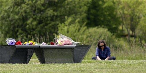 A woman sits in the grass near a flower-covered bench at the Sound Garden sculpture, for which the band Soundgarden was named, in Seattles Magnuson Park, Thursday, May 18, 2017. Both Colgan and White, fans of the band, came to the park to honor Cornell. Seattle awoke Thursday to the news of the death of Cornell, 52, among its most famous musicians and one whose forceful, somber songs helped cement the citys place in rock history. (AP Photo/Elaine Thompson)
