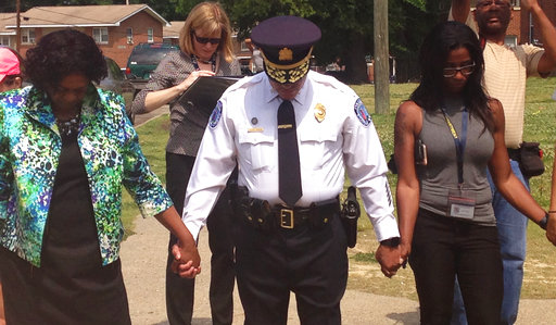 In this photo, Richmond Police Chief Alfred Durham and others pray after a news conference on Saturday, May 27, 2017 in Richmond, Va.. Authorities say Special Agent Michael T. Walter was shot Friday after he and a City of Richmond police officer approached a vehicle parked on a street in Mosby Court.  Travis A. Ball is being held without bond on charges that include malicious wounding and use of a firearm in the commission of a felony. (AP Photo/Alanna Durkin Richer)