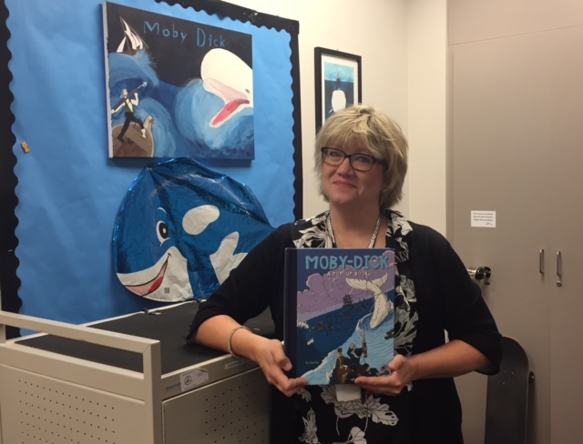 NPHS English teacher Ellen McKee poses with teaching artifacts of her favorite work, Moby-Dick. McKee recently completed a masters thesis on Melvilles epic novel.