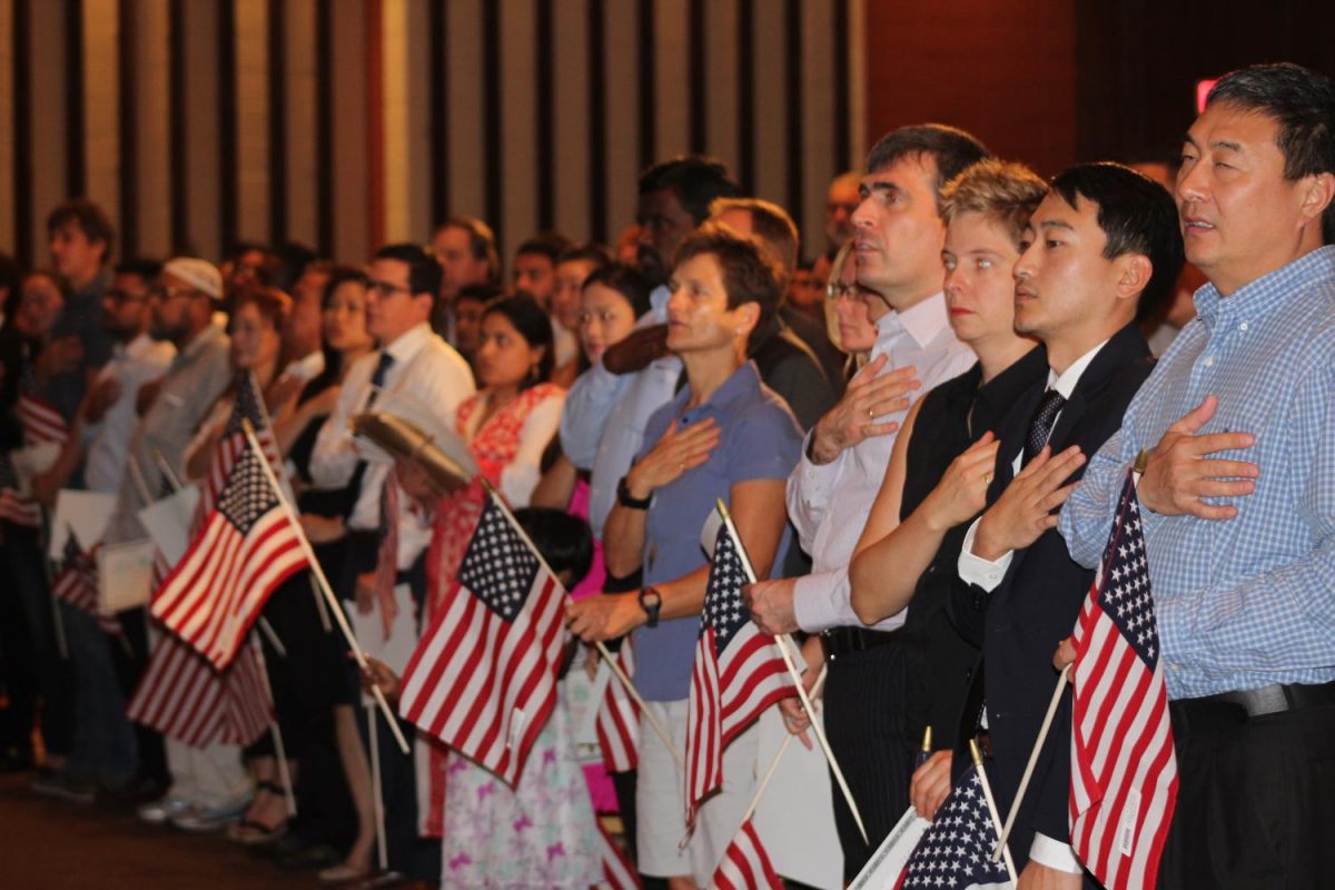 New citizens stand for playing of the National Anthem