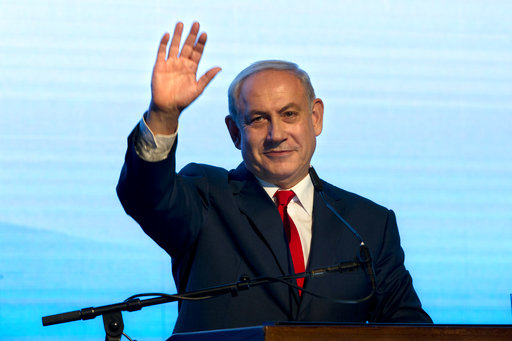 Israeli Prime Minister Benjamin Netanyahu waves during a rally of his Likud party supporters, near Tel Aviv, Israel, Wednesday, Aug. 30, 2017. Israeli Prime Minister Benjamin Netanyahu has lashed out at the fake news industry over media coverage of investigations into corruption allegations. (AP Photo/Sebastian Scheiner)