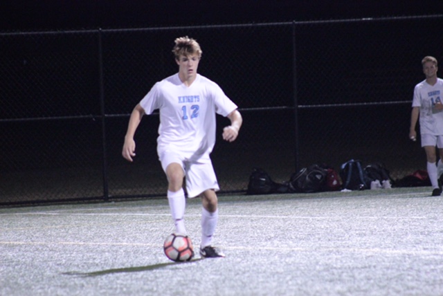 Johnston looks for a pass during a soccer game.