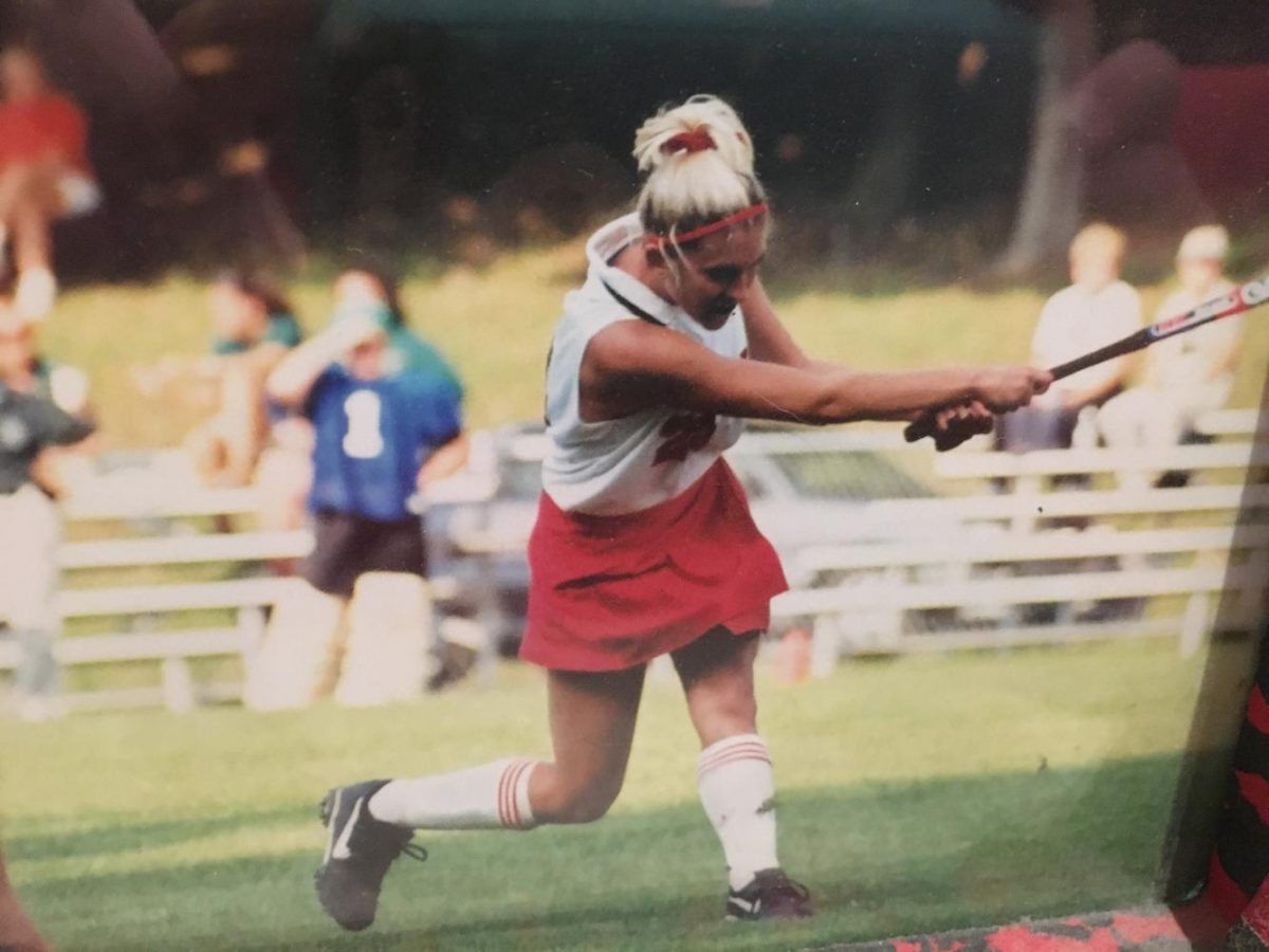 Shannon McCracken follows through after hitting a ball while playing collegiate hockey.