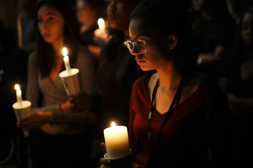 Natalynn Rivis, a student at University of Nevada Las Vegas, right, takes part in a vigil Monday, Oct. 2, 2017, in Las Vegas. A gunman on the 32nd floor of the Mandalay Bay casino hotel rained automatic weapons fire down on the crowd of over 22,000 at an outdoor country music festival Sunday. (AP Photo/Gregory Bull)