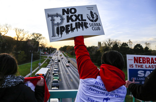 Opponents of the Keystone XL pipeline demonstrate on the Dodge Street pedestrian bridge during rush hour in Omaha, Neb., Wednesday, Nov. 1, 2017. The Nebraska Public Service Commission must decide by Nov. 23 whether to approve or reject the pipelines proposed route through the state. (AP Photo/Nati Harnik)