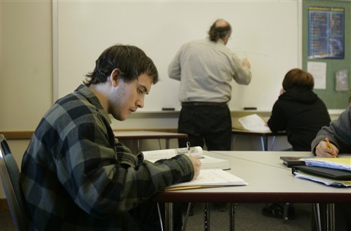 Josh Stroder, left, studies at the Montgomery City Youth Center as math teacher Ed Hall, center, works with a youth offender, right, Monday, Dec. 3, 2007, in Montgomery City, Mo. Stroder spends much of his days studying and working as a tutor to other youths at the center. In Missouri, where teen offenders are viewed not just as inmates but as works in progress, troubled kids are rehabilitated in small, homelike settings that stress group therapy and personal development over isolation and punishment. (AP Photo/Jeff Roberson)