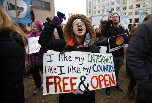 Lindsay Chestnut of Baltimore holds a sign that reads I like My Internet Like I Like my Country Free & Open as she protests near the Federal Communications Commission (FCC), in Washington, Thursday, Dec. 14, 2017, where the FCC is scheduled to meet and vote on net neutrality. The vote scheduled today at the FCC, could usher in big changes in how Americans use the internet, a radical departure from more than a decade of federal oversight. (AP Photo/Carolyn Kaster)