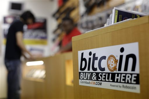 In this Wednesday, Aug. 20, 2014 photo, Jon Rumion, background left, talks with Michael Cargill at Central Texas Gun Works, in Austin, Texas. Rumion purchased two guns at the store using bitcoin. As states debate the merits of bitcoin, Texas is emerging as a vital testing ground for the digital currency. (AP Photo/Eric Gay)